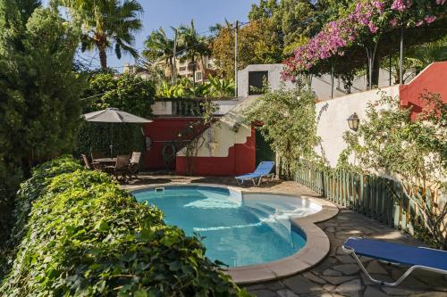 a swimming pool in a yard with trees and flowers at Quinta Florença - By WeHost in Funchal