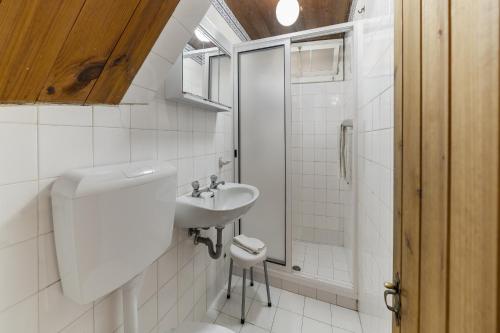 a white bathroom with a sink and a shower at Quinta Florença - By WeHost in Funchal