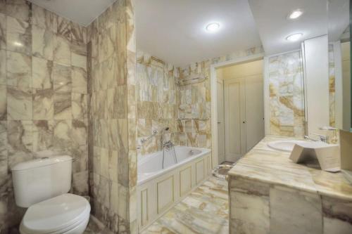 une salle de bain avec toilettes, baignoire et lavabo dans l'établissement Rocher Saint Georges spacieux 3P jardin piscine, à Cannes