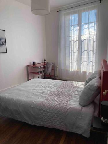 una camera con un grande letto e una finestra di Appartement Notre Dame 2 a Montluçon