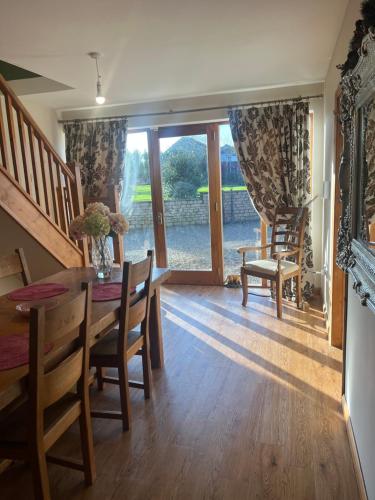 een eetkamer met een tafel en stoelen en een raam bij Highcroft House in Corsham