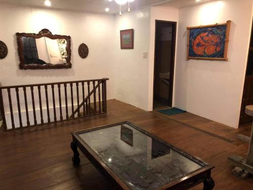 a living room with a glass table and a mirror at Heart of Paete Laguna, Camarero Transient House in Paete
