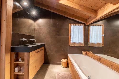 a bathroom with a bath tub and a sink at Chalet Alpen in Praz-sur-Arly