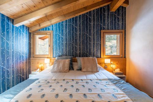 a bedroom with a bed with a blue wall at Chalet Alpen in Praz-sur-Arly
