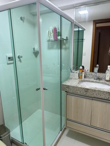 La salle de bains est pourvue d'une douche en verre et d'un lavabo. dans l'établissement Barra Grande Exclusive Residence, à Marau