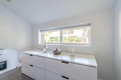 a kitchen with white cabinets and a window at Cute as a Button! in Seattle