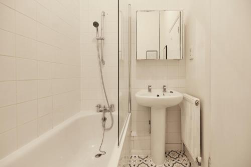 y baño blanco con lavabo y ducha. en The Crystal Palace Crib - Lovely 1BDR Flat, en Crystal Palace