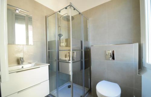une salle de bain avec une douche, des toilettes et un lavabo dans l'établissement Résidence Delattre, à Cannes
