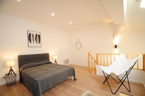 - une chambre avec un lit et une chaise blanche dans l'établissement Résidence Delattre, à Cannes