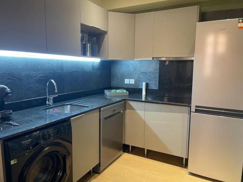 a kitchen with a washer and a sink and a dishwasher at Appartement standing pour 4 in Toulon