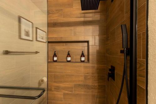 a bathroom with a shower with three bottles at Lux Modern Getaway with ATT Stadium Views and King Bed in Arlington