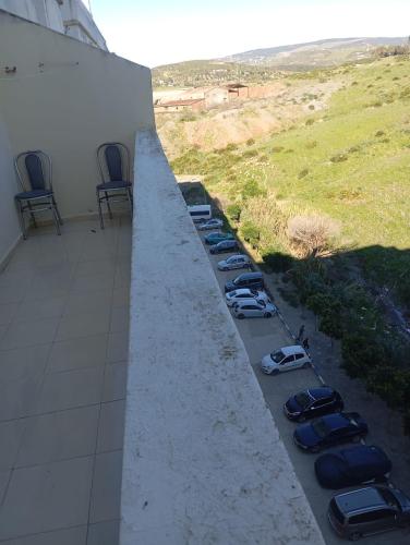 een rij geparkeerde auto's geparkeerd naast een gebouw bij إقامة النور قرب مرجان مغوغة in Tanger