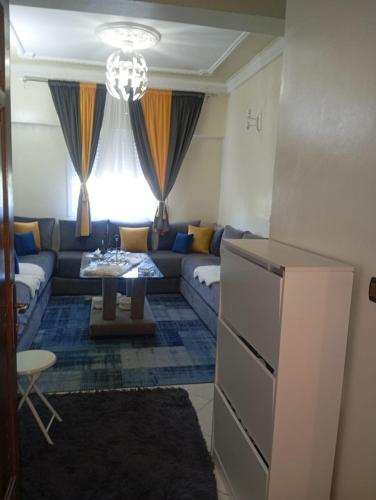 een woonkamer met een bank en een tafel bij إقامة النور قرب مرجان مغوغة in Tanger