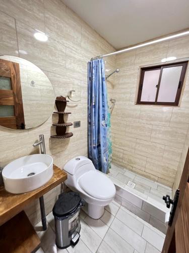 a bathroom with a toilet and a sink and a mirror at Moderna Casa - Playa Puertecillo in Navidad