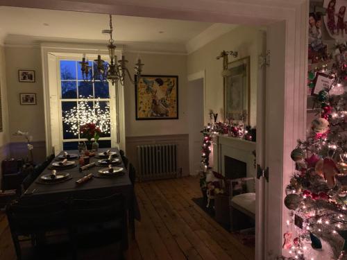 a living room with a christmas tree and a table at Stunning Georgian ‘Squires’ Town House - near London in Hertford