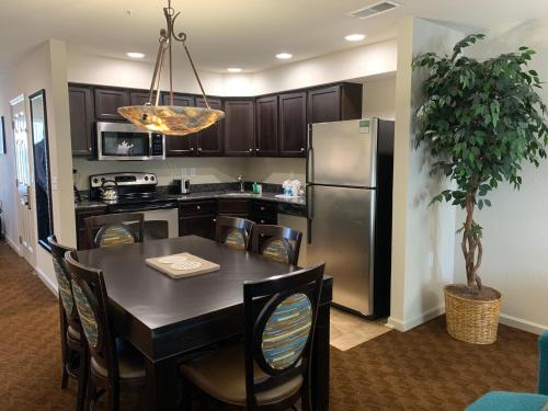 a kitchen with a table and a stainless steel refrigerator at The Colonies at Williamsburg in Williamsburg