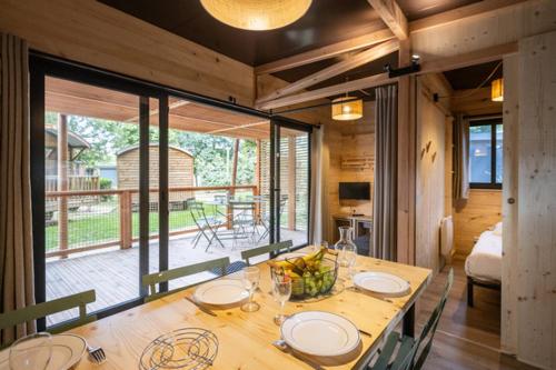 a dining room with a wooden table with plates on it at CityKamp Paris in Paris