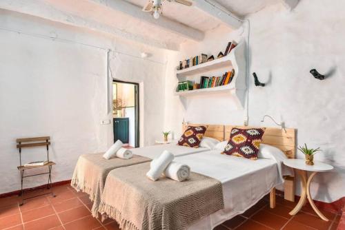 two beds in a room with white walls at Finca BellaMirada in Es Mercadal