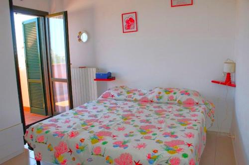 1 dormitorio con 1 cama con colcha de flores en BILO CAMERINO a due passi dal mare, con wifi, en Marcelli