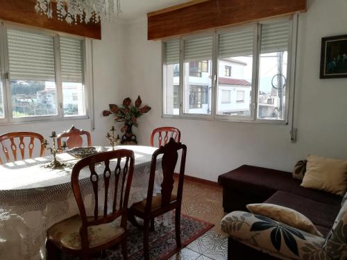 a dining room with a table and chairs and windows at Casa Arcade in Sotomayor