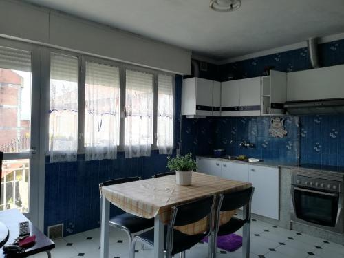 a kitchen with a table and chairs and blue walls at Casa Arcade in Sotomayor