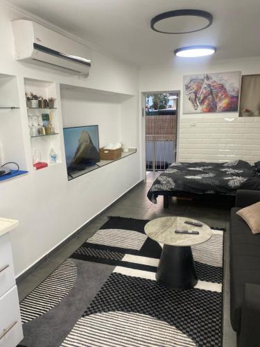 - un salon avec un lit et une table dans l'établissement נופש בעמק, à Beït Shéan