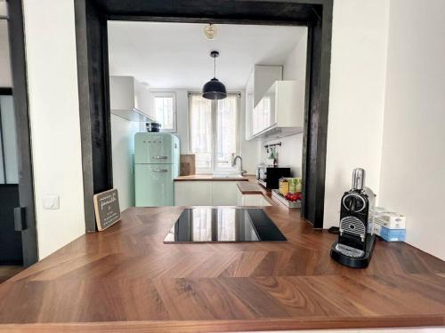 Cette chambre comprend une cuisine équipée d'un réfrigérateur et d'une table. dans l'établissement Appartement refait à neuf à 2 min du Chateau, à Versailles
