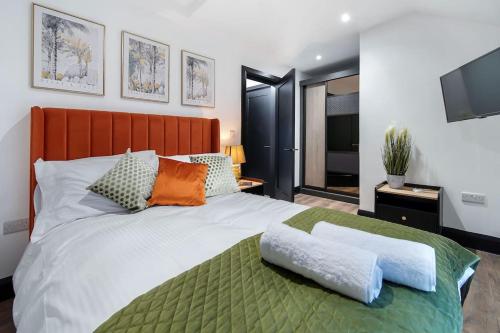 a bedroom with a large bed and a television at The Eden Loft: A Stylish Retreat in Strabane