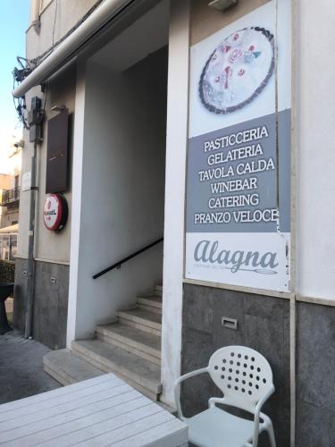 a sign on the side of a building with a chair at Marsala al centro n 9 in Marsala