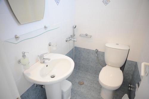 a bathroom with a white toilet and a sink at Maroussa Studios in Agia Anna Naxos