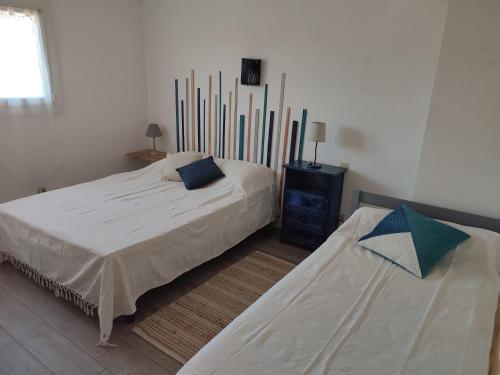 1 Schlafzimmer mit 2 Betten, einer Kommode und einem Bett sidx sidx in der Unterkunft Maison 10min à pied de la plage in Saint-Cyprien