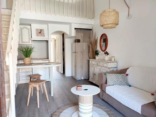 a living room with a couch and a kitchen at Maison 10min à pied de la plage in Saint-Cyprien