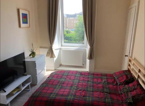 a bedroom with a bed and a large window at Cosy, large double room in a shared flat in Edinburgh