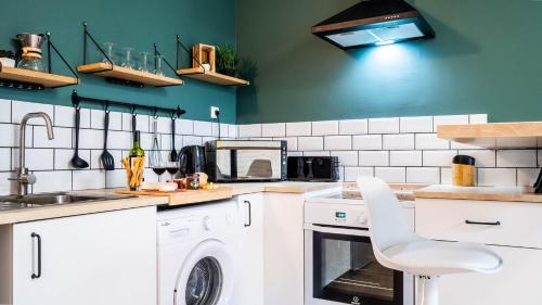 a kitchen with white appliances and green walls at Le Contemporain - Bel appartement T2 à Poitiers in Poitiers