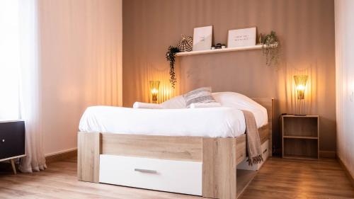 Cette chambre comprend un lit avec des draps blancs et une télévision. dans l'établissement Le Contemporain - Bel appartement T2 à Poitiers, à Poitiers