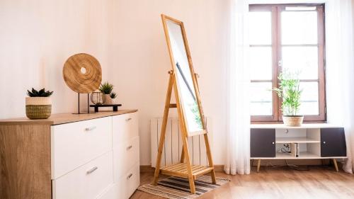 un miroir au-dessus d'une commode dans une pièce dans l'établissement Le Contemporain - Bel appartement T2 à Poitiers, à Poitiers
