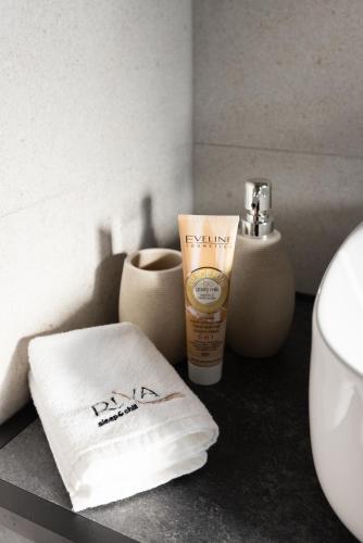 a bathroom counter with a towel and a bottle of sunscreen at RIVA sleep & chill in Valjevo