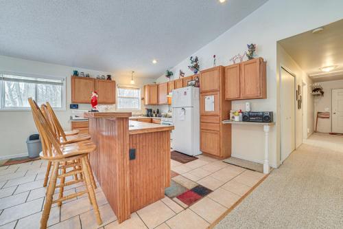 a kitchen with wooden cabinets and a white refrigerator at Secluded Mancelona Home with Gas Grill! in Mancelona