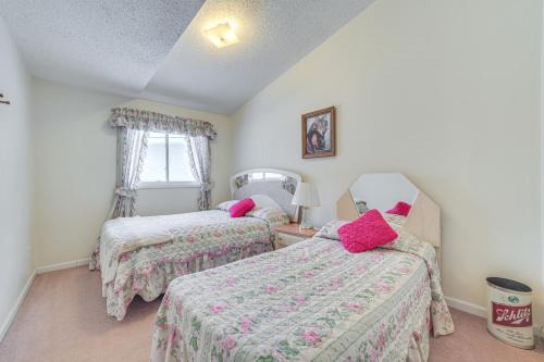 a bedroom with two beds with pink pillows at Secluded Mancelona Home with Gas Grill! in Mancelona