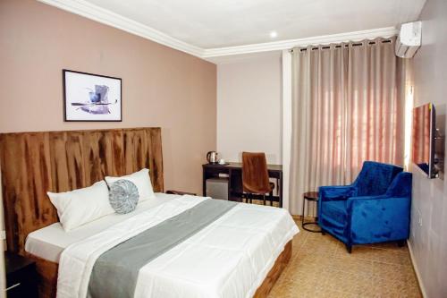 a bedroom with a bed and a chair and a desk at Nexus Xpress Hotel in Abuja
