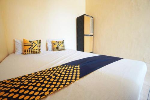 シドアルジョにあるOYO 93300 Homestay Puri Anggrek Syariah - Wageのベッドルーム1室(黄色と青の枕が備わるベッド2台付)