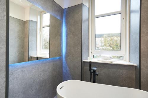 a bathroom with a white tub and a window at Lovely, Recently Refurbished Two Bedroom Apartment in Glasgow