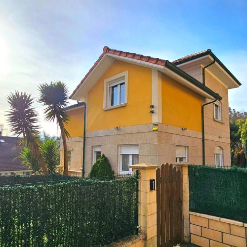 a yellow house with a fence in front of it at Viento Del Norte in Pomar