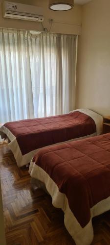 Duas camas num quarto com uma janela em Departamento 4 ambientes, 3 hab em Buenos Aires