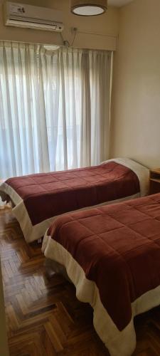 Dos camas en una habitación con ventana. en Departamento 4 ambientes, 3 hab, en Buenos Aires