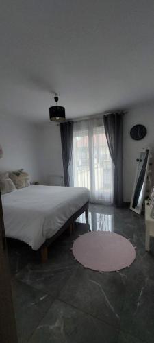 ein Schlafzimmer mit einem Bett und einem großen Fenster in der Unterkunft Maison individuelle avec jardin in Vaujours