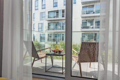 a balcony with two chairs and a table and a building at Yacht Park Marina in Gdynia