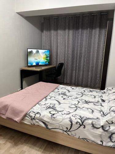 a bedroom with a bed and a desk with a computer at Apartment for relax in Chişinău
