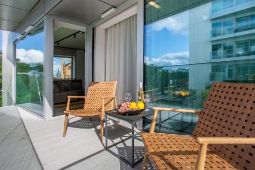 a patio with two chairs and a table on a balcony at Yacht Park Marina in Gdynia