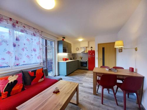 un soggiorno con divano rosso e tavolo di Apartment Mölltaler Gletscher 8 a Ausserfragant